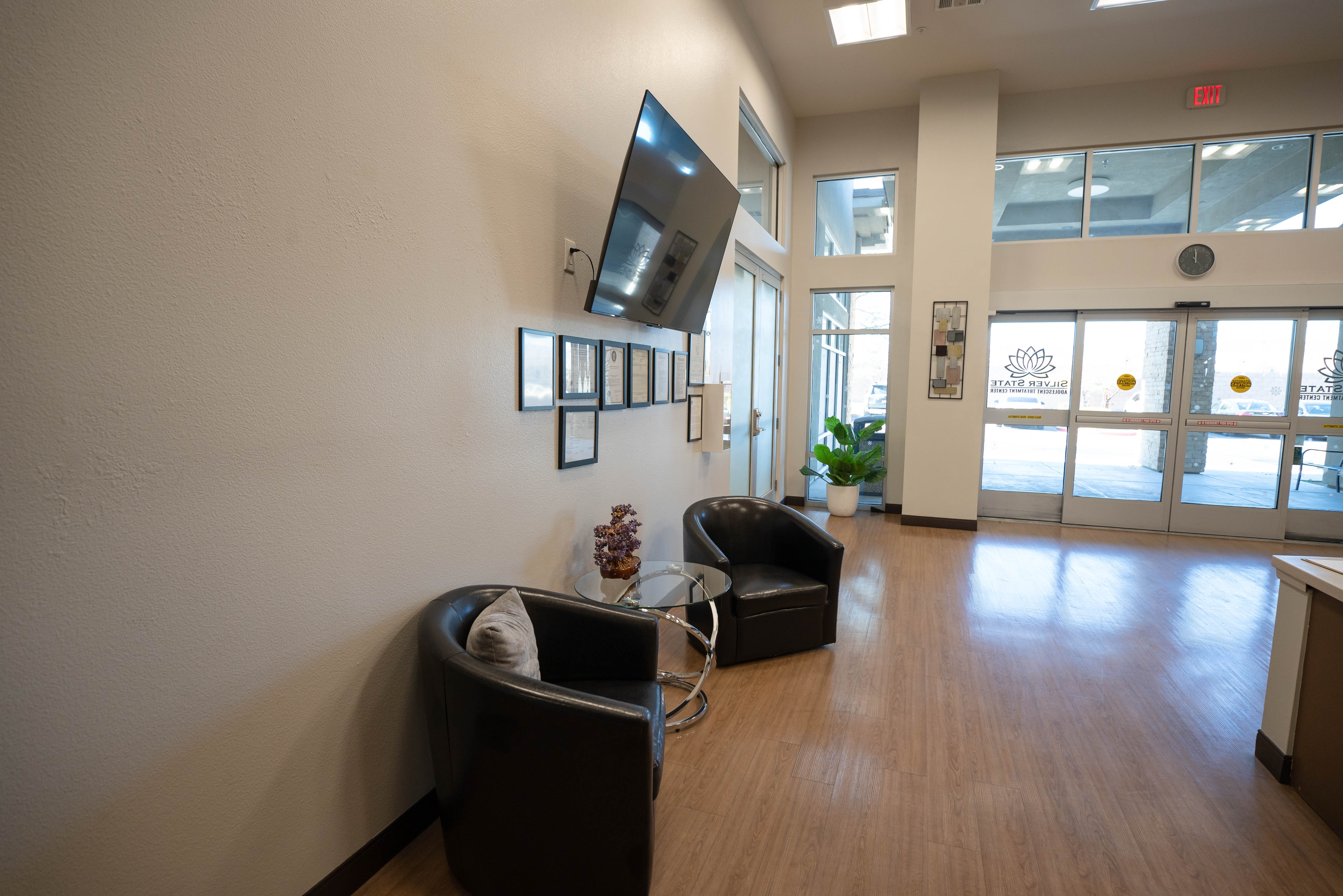Silver State lobby seating area with TV and certificates